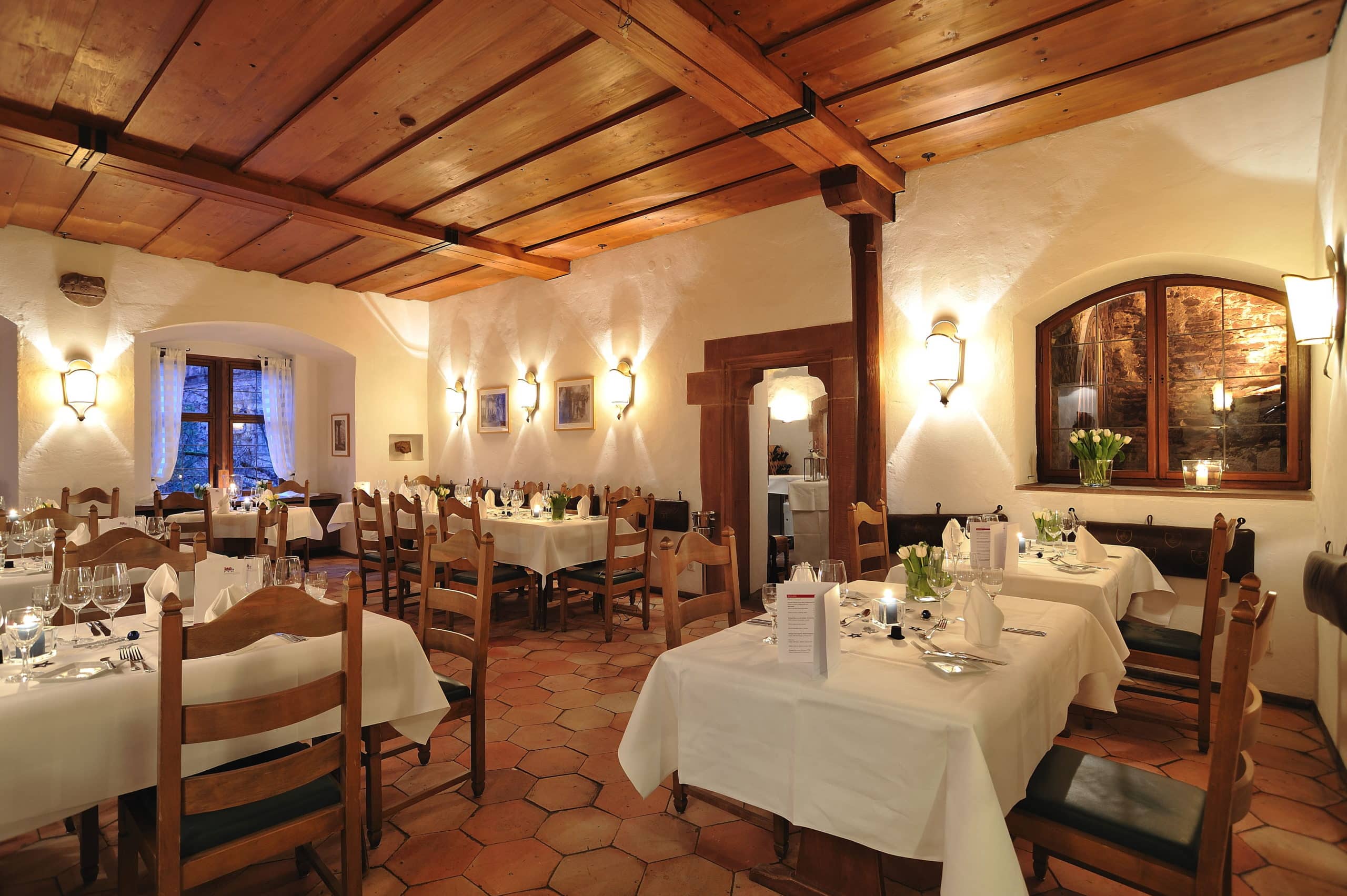 Das rustikale Backhaus ist mit weiß eingedeckten Tischen für eine Veranstaltung vorbereitet